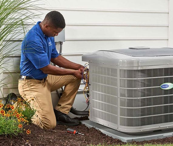 HVAC service technician working on a carrier heat pump