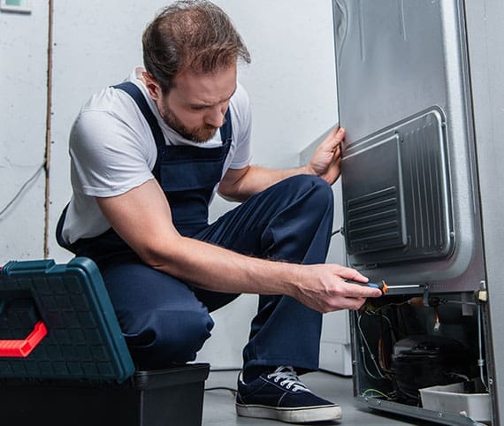 HVAC technician opening side of a furnace for repair