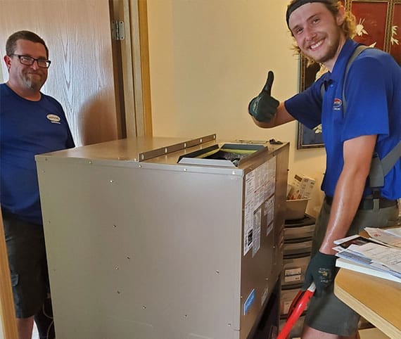 Shackelford technicians installing furnace smiling and giving thumbs up