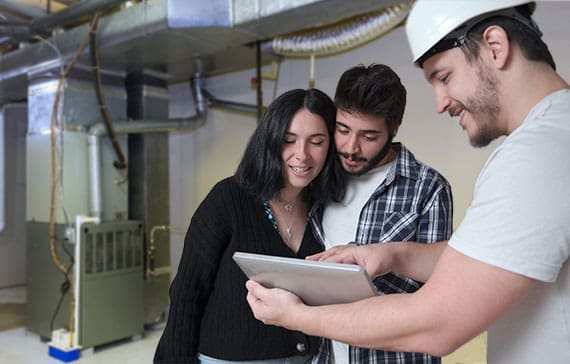 HVAC service tech showing a couple an estimate on a tablet