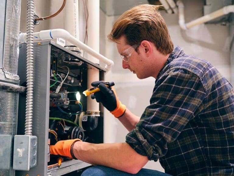 A man working on an HVAC unit