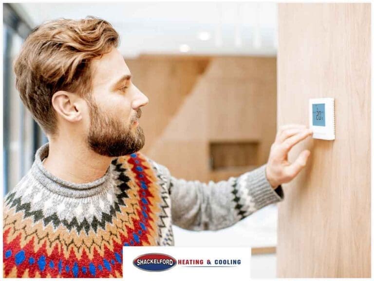 A man checking his thermostat