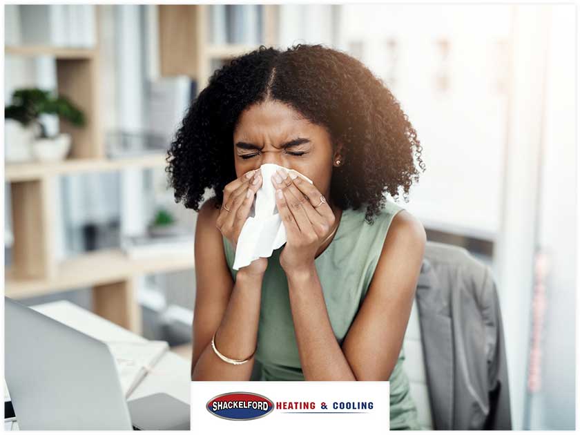 A women sneezing in the workplace