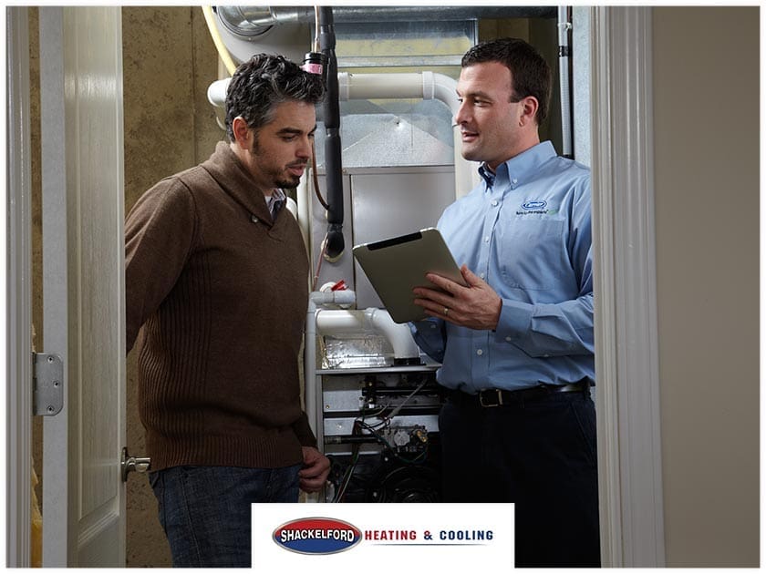 A technician explaining to a man about his new HVAC system