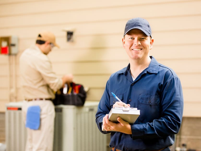 A man just finishing installing an HVAC unit