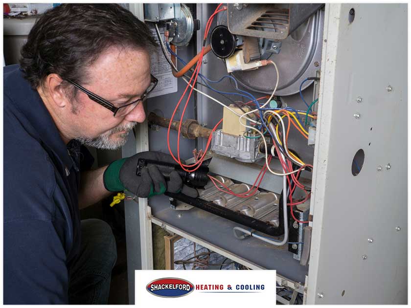 A man doing maintenance on an heating system