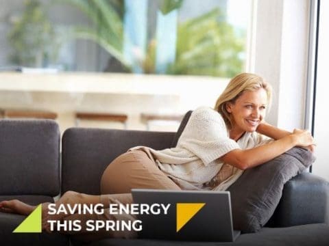 Women laying on her couch looking happy