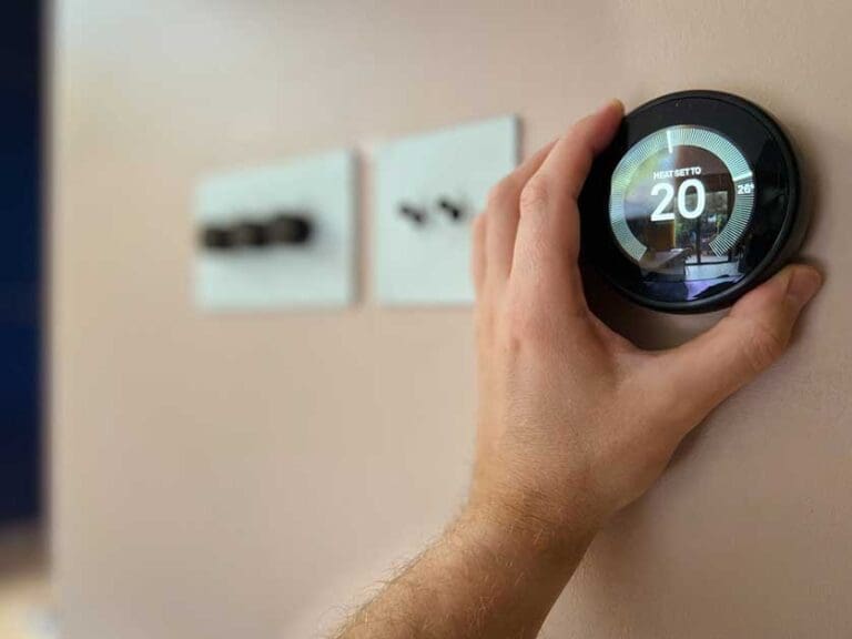 A person looking at a Smart thermostat