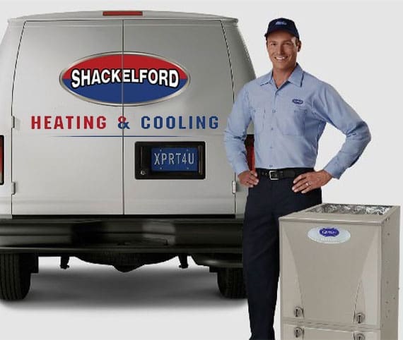 HVAC service technician standing in front of a service van with a new furnace
