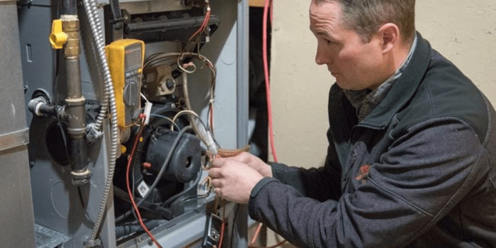 A man Doing Maintenance on a Furnace.