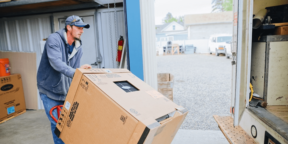 A man loading a new system into a truck to be installed.